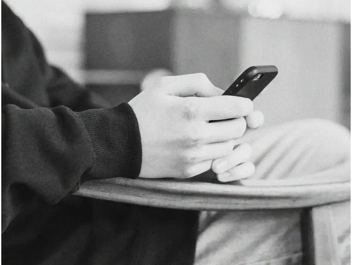 Personne tenant un smartphone en position assise