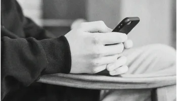 Personne tenant un smartphone en position assise