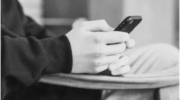 Personne tenant un smartphone en position assise